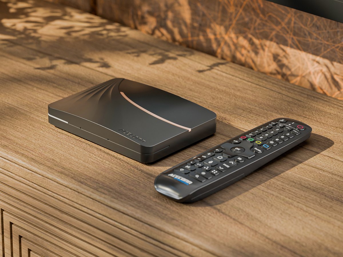Aceconn TV box and remote control on a wooden media console