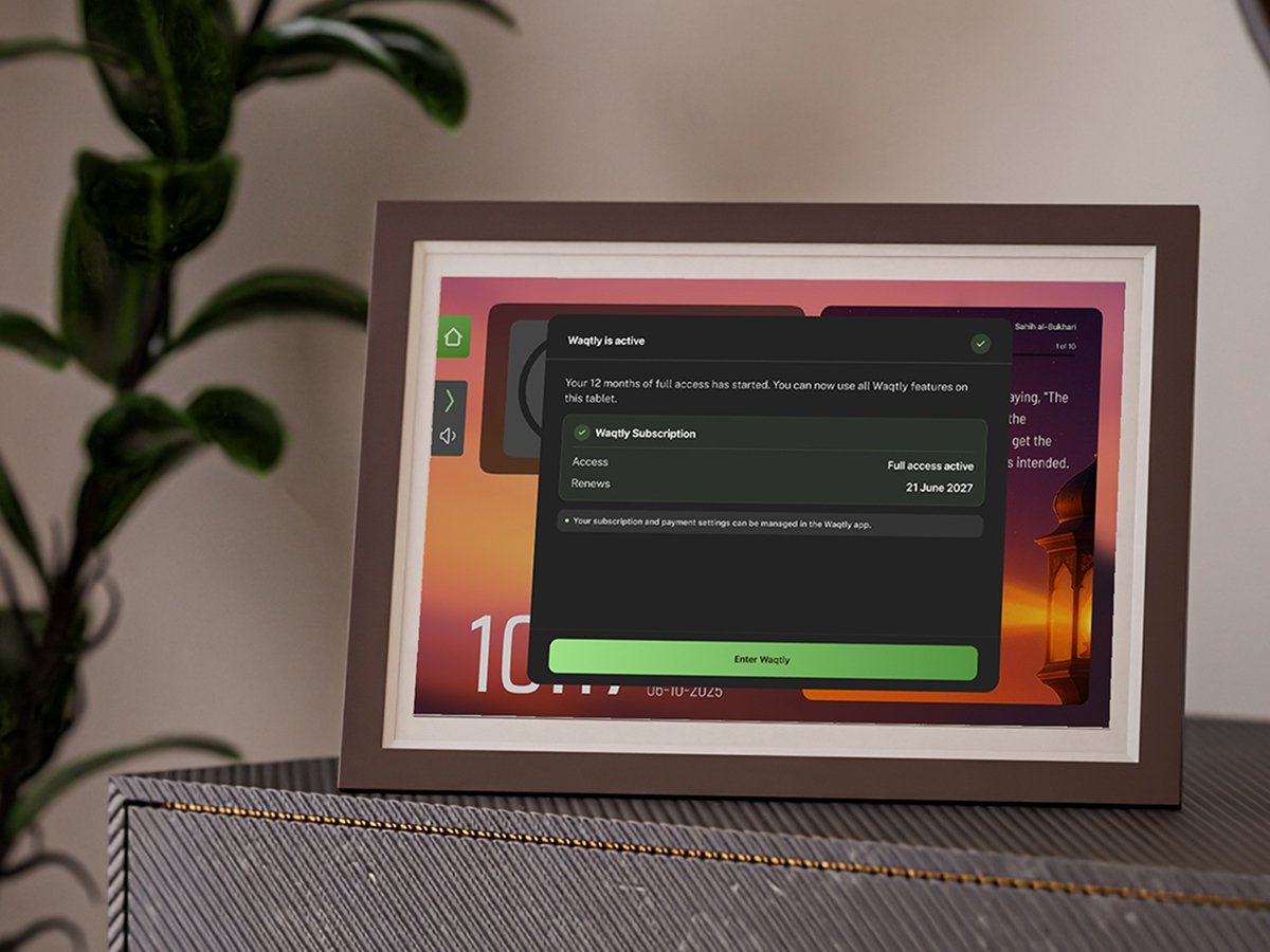 Waqtly smart frame on a sideboard showing a "Waqtly is active" subscription confirmation screen